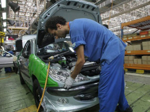 MAKING FEWER CARS — A worker assembles a car on an assembly line in Iran.