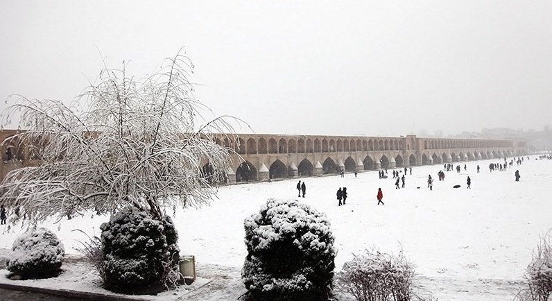 WINTER WONDERLAND — The Khaju Bridge over the Zayandeh River in Esfahan was built in 1650 but often lies high and dry as the river has gone dry for several months each year recently.  But last week, there was water that froze over and a rare snowfall that drew people to stroll on the river.