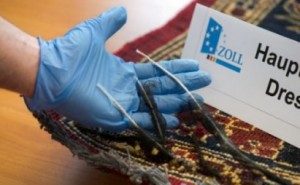 NOVEL TACTIC — A German customs officer shows the heroin he found woven into a Persian carpet.
