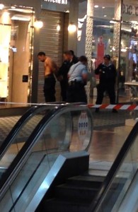 ARRESTED — Kazem Mohamadi-Payam (shirtless) is handcuffed by police in the shopping mall.