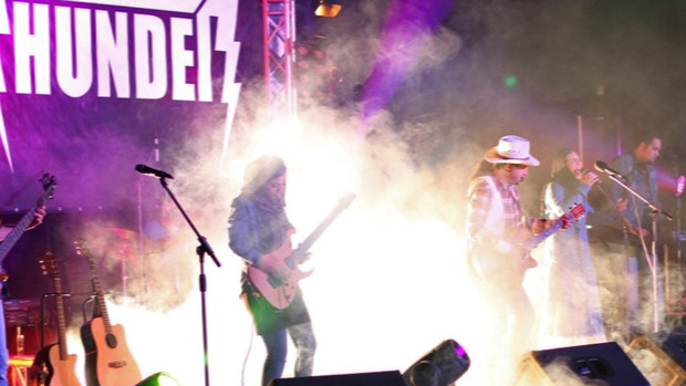 ROCKING — The band Thunder performs at a concert with Ardavan Anzabipour in the country western hat and female vocalist Sanam Pasha lit up at center stage by the pyrotechnics.