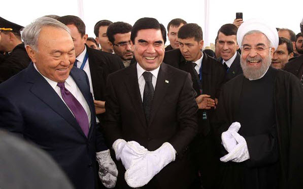 HAPPY PRESIDENTS — Below, from left, Presidents Nazarbayev of Kazakhstan, Berdy-muhamedov of Turk-menistan and Rohani of Iran don gloves as they prepare to tighten the last rail on the new link.  At left, the first train pulls into the station.                  