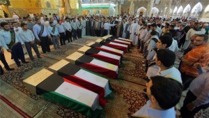 MOURNING — Kuwaiti Shias line up behind the coffins of some of those killed in the bombing.