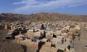 SCENE — This is the set for the film, showing Mecca as a village 1,400 years ago with the Kaaba nestled in the center, surrounded by mud-walled houses.