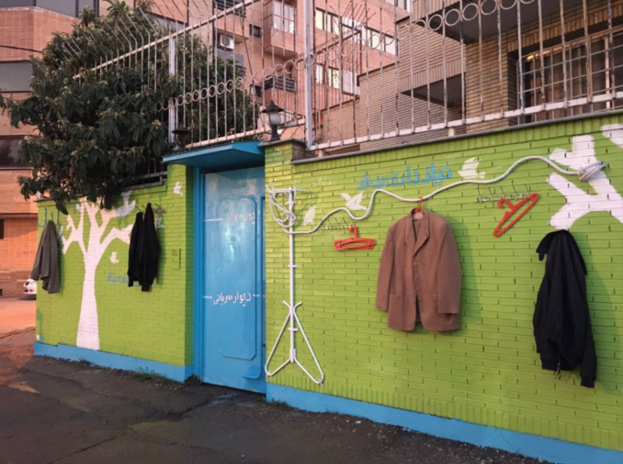 NEW FORM OF CHARITY — This is one of the “walls of kindness” in Shiraz, freshly painted with hangers holding clothes for the needy.