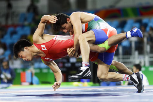 TOPPLED — Hamid Soryan (blue) held on to his wrestling opponent but couldn’t hold on to his title and ended up ranked 11th.