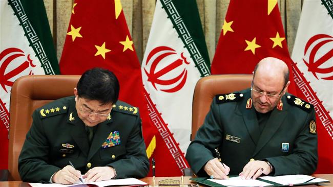 MYSTERY PACT — Chinese Defense Minister Chang Wanquan (left) and Iranian Defense Minister Hossain Dehqan sign an agreement on military cooperation Monday in Tehran.  No one said what kind of cooperation the agreement provides for.