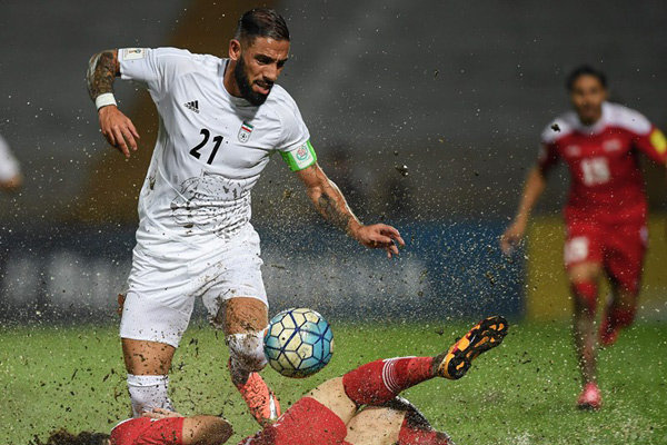 DIRTY PLAY — The mud flies all over everyone as Ashkan Dejagah (in white) tries to take control of the ball from a Syrian player who had slipped in the mud.  No one got much control of the ball on the sloppy field and play ended in a 0-0 tie Tuesday.