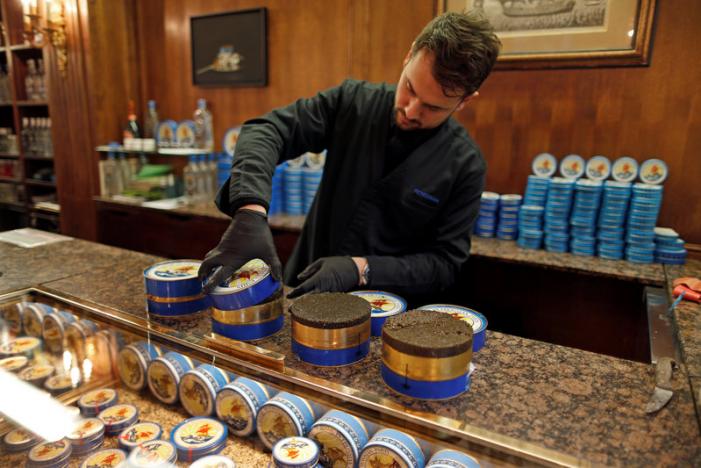 BLACK GOLD — An employee at Petrossian’s in Paris, is packing up more tins of caviar these days as the market starts to recover.