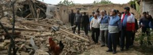 Checking - Officials look over the damage from the quake last month.