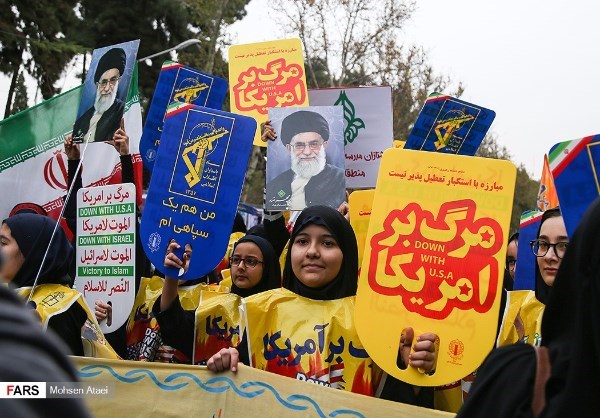 TIME TO CHANT — The turnout was larger this year at the annual anti-American rally to mark the November 4, 1979, seizure of the US Embassy in Tehran.  There were also some new signs, like those yellow ones saying “Death to America,” and the yellow slickers these girls are wearing are also new and  also say “Death to America.”