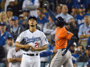 Yu Darvish closes his eyes as he sees his season ending badly while George Springer rounds the bases behind him after hitting a home run off Darvish.