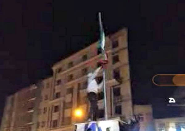 Teen is photographed pulling down Iranian flag.