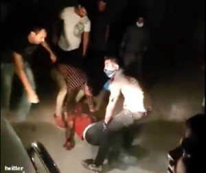 HELP—Protestors help injured man in Kazeroun.