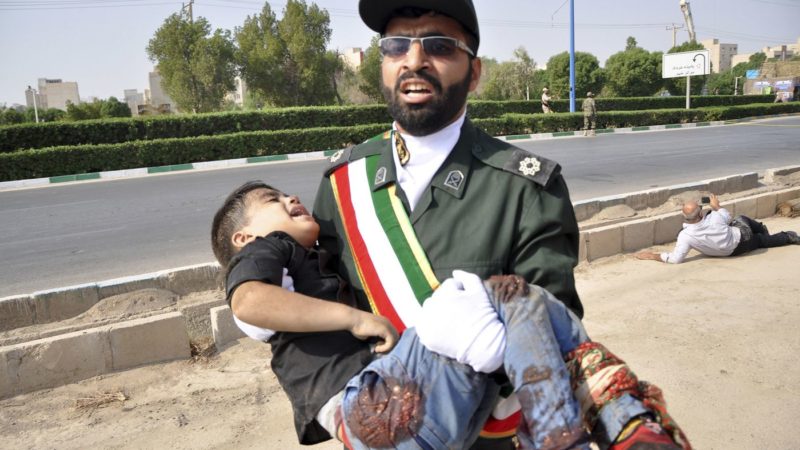 VICTIM — A Pasdar officer carries a four-year-old child, Mohammad Taha, who was injured in the terrorist attack.  The boy later died.