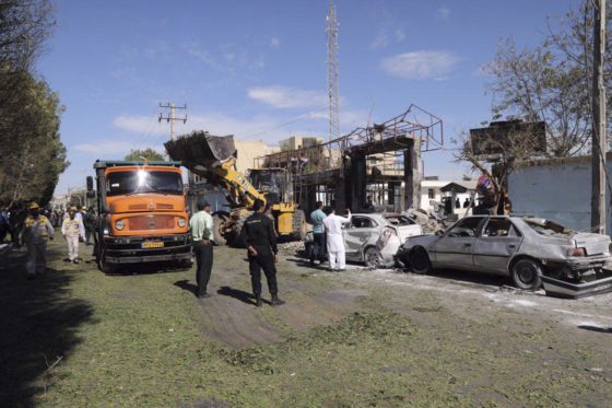 CLEANUP — Workmen clean up the rubble left after a car bomber blew up his vehicle at the entrance to the Chabahar police headquarters. 