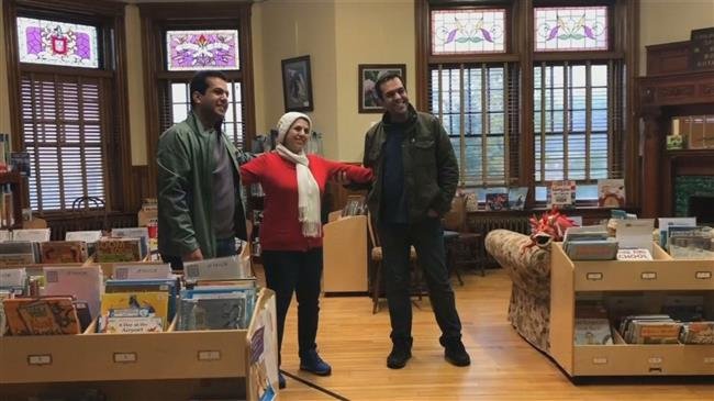 REJOINED — An Iranian mother meets her sons at the border with one foot in Canada and one in the United States.  The line on the floor marks the international border.