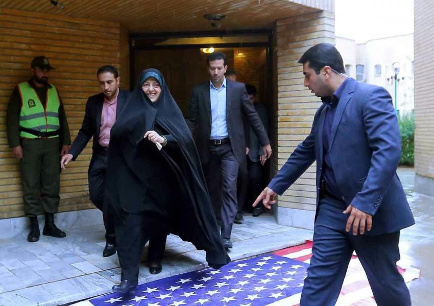 POLITICAL STATEMENT — Vice President Masumeh Ebtekar walks over a US flag as she emerges from an office building in Tehran. 