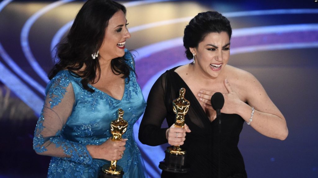 THE WINNER — Rayka Zehtabchi (right) gasps as she holds her Oscar for the documentary she directed.  With her is the producer, Melissa Berton.