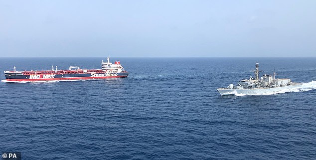 ESCORT — A British warship (right) escorts a British-flagged tanker through the Strait of Hormuz.