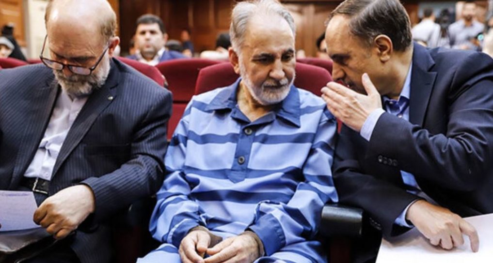 ON TRIAL — Former Tehran Mayor Mohammad-Ali Najafi sits in court in prison garb and handcuffed and consults with his defense lawyer.