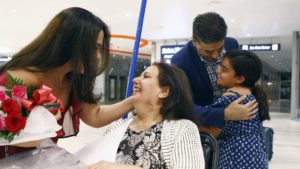 WELCOME — Iranian-American Damineh Oveisi (left) welcomes her mother to Tampa, Florida, while her daughter, Leyana, welcomes her granddad.