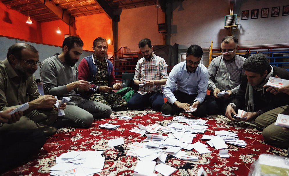 FINDING THE WINNERS — Election officials in Hamadan count the ballots the usual way, by dumping then on a carpet and picking them up one by one