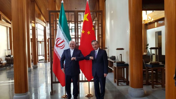 GREETING — Chinese Foreign Minister Wang Yi (right) greets his Iranian counterpart, Mohammad-Javad Zarif, elbow-to-elbow before the pair sit down to talk about a “Comprehensive Strategic Partnership.”  The talks were announced four years ago, but nothing has yet materialized.