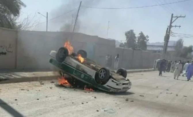 ANGRY—Baluchi rioters in Saravan overturned and set fire to this police car.