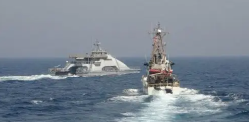 CLOSE ENCOUNTER — A Pasdaran catamaran (left), larger than its usual gunboats, sails directly across the bow of the US Coast Guard patrol boat Monomoy during an encounter April 