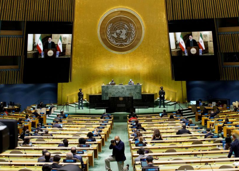 DISTANCE LEARNING — President Raisi (seen on screens in background) sent his first speech to the UN via videotape.  Hardly anyone attended.