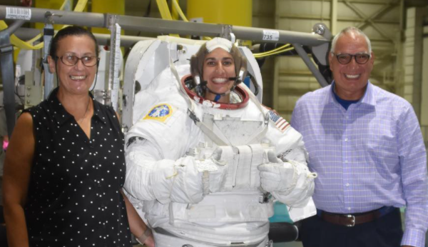 ON THE WAY UP — Jasmin Moghbeli, in her cumbersome space suit, is flanked by her parents as they visited her during her NASA training.
