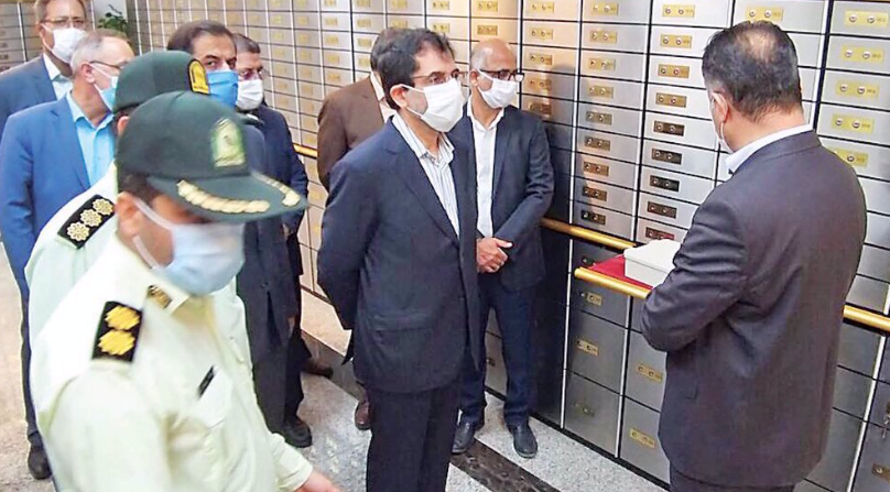 BREAK-IN — Bank Melli staff and police (above) check out the bank of safe deposit boxes that thieves emptied after they broke into the bank over the three-day holiday weekend for the death anniversary of Ayatollah Khomeini. Below, news photographers take pictures of some of the 13 suspects the police say they have arrested for the crime.