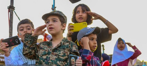 ALL TOGETHER NOW — Kids salute a bit haphazardly as they sing “Salam, Farmandeh,” the new pop tune being pushed by the regime.