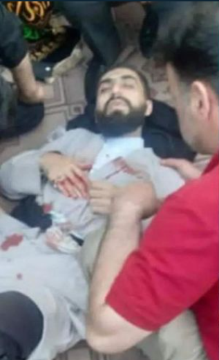 FIRST AID — Bystanders help Mojtaba Hossaini moments after he was stabbed repeatedly in the back, becoming the sixth cleric attacked this year.