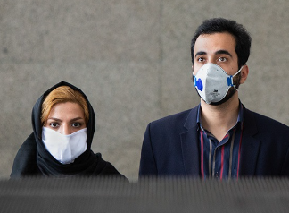 MASKING UP — Mask wearing is by no means universal in Iran, but large numbers of the public have continued to wear masks, like this couple emerging from the Tehran Metro. And officials have tried to set an example by wearing masks.