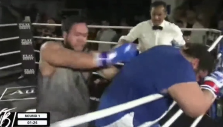 ON THE ROPES — It turned out the Iranian Hulk (in blue shirt) never learned how to box before entering the ring. He spent most of his time clutching the ropes for protection. The match was stopped in two minutes.