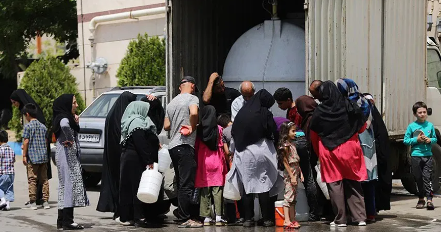 WETTING THEIR WHISTLES — These residents of Hamadan lined up at a water tanker truck to get clean water. Others rioted over the failure of the city water system to supply water to homes.